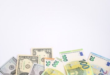 Euro and US dollar banknotes scattered on a white background with copy space. Concept of international finance, currency exchange, business, and global economy suitable for commercial design projects.