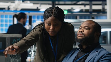 Black specialists engineers doing teamwork on modern production line for solar panels power, combining technical insight and collaboration for renewable energy infrastructure. Camera B.