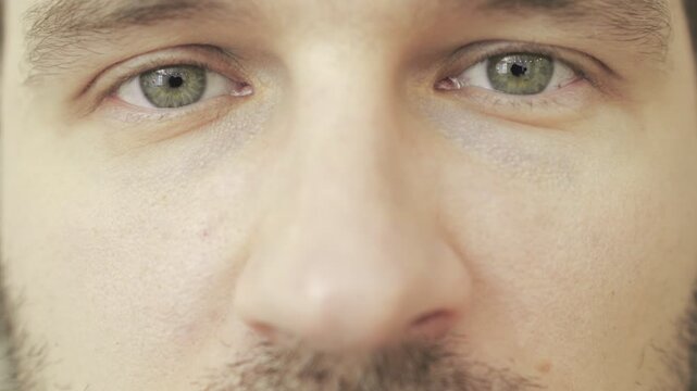 Eyes of sad young man looking at camera. Eye care, vision concept. Slow motion