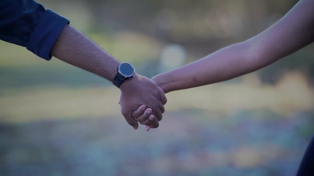 Couples holding their hands romantically and walking together.Slow-motion video with  selective focus of hands without face.