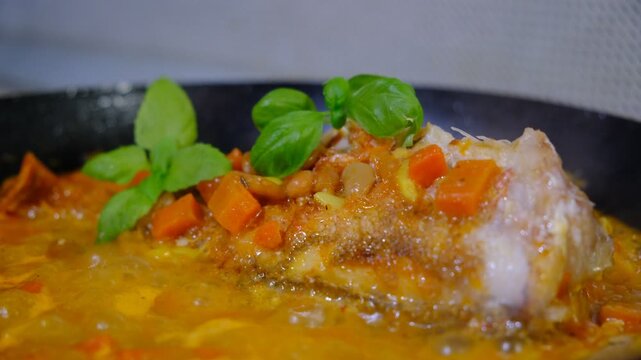 Fresh Red Snapper hot in the frying pan with carrot, garlic, basil,  savoury sauce, vegetables garnish. Brazil food. Sebastes babcocki fish. A deep fried fish topped with chili.