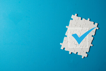 Quality control and assurance concept. A jigsaw puzzle with a checkmark, representing the final piece of a business strategy, successful problem-solving, and the integration.