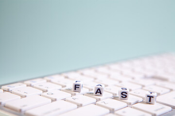 FAST word made with building blocks on computer keyboard, business concept