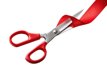 Red ribbon-cutting scissors.  Sharp scissors with red handles are cutting a red ribbon against a black background.  Close-up view