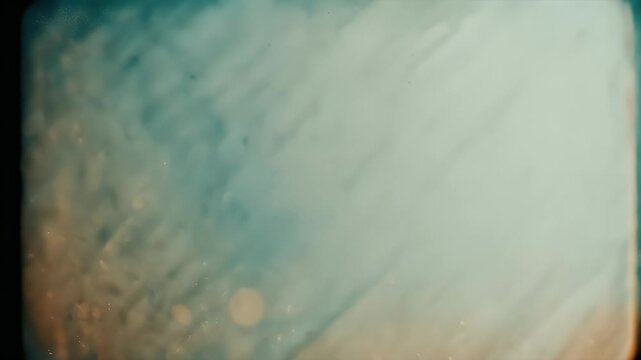 An abstract, sepia-toned image with a blurry texture, scratches, and light flares