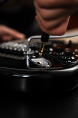 Plugging Cable into Electric Guitar close-up. Jack cable is plugged into the black electric guitar, activating its signal path for rich tones and stage-ready sound.