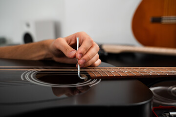 Fine-tuning an acoustic guitar truss rod with precision using an Allen key. Adjusting a guitar truss rod. Guitarist adjusting the truss rod inside the acoustic guitar.
