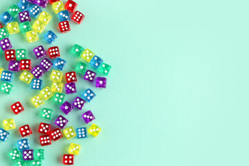 Many colorful game dices on turquoise background