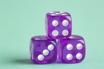 Purple game dices on turquoise background