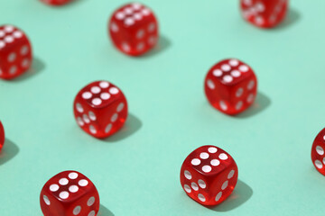 Many red game dices on turquoise background