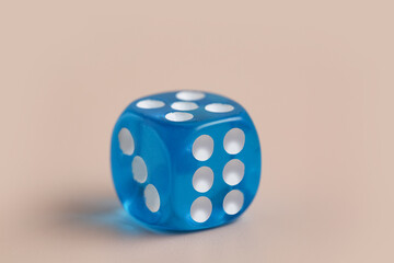 Blue game dice on beige background