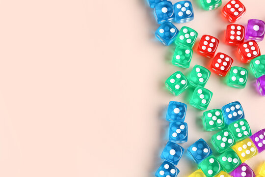 Many colorful game dices on beige background