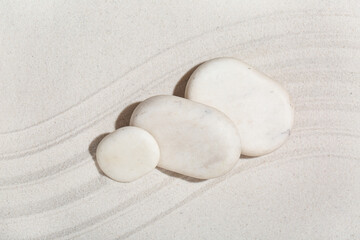 Spa stones on light sand with lines. Zen concept