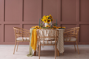 Elegant table serving with plates, candles and beautiful sunflowers