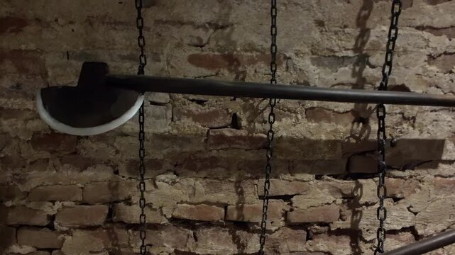 Executioner's battle axe on display in Castle , , gothic medieval punishment weapon in dim dungeon setting