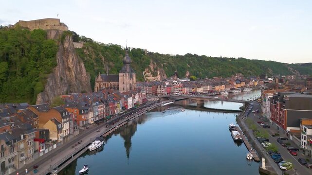 citadel church meuse river traffic bridge boats town dinant belgium scenic urban dynamic forward aerial shot collegiate backdrop 