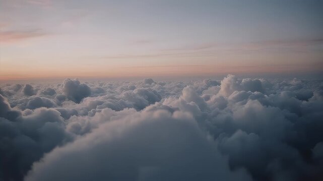 A serene view of clouds illuminated by the dawn sky, creating a soft and dreamy aerial perspective
