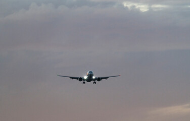 Silhouette of Airplane Landing at Sunset