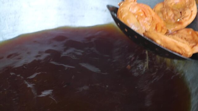 Snacks made of dough are fried in the hot oil of a kadai. Handmade crunchy salty snack food. 