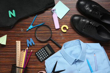 Different stationery with stylish school uniform on wooden background