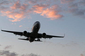 Passenger Jet Approaching Runway During Vibrant Sunset