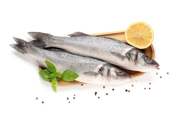 Board with fresh uncooked sea bass fish, basil leaves and lemon isolated on white background, closeup