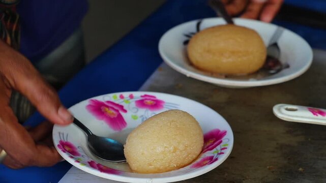 Sweet rasgulla, simmering in a sweet syrup in a large cauldron.