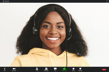 Closeup portrait of joyful african american millennial woman with bushy hair sitting on couch,...
