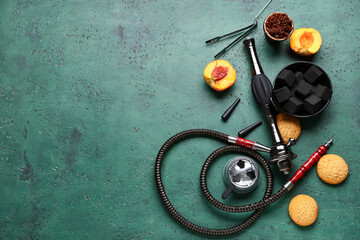 Parts of hookah with tobacco, peach and cookies on green grunge background