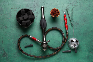Parts of hookah with tobacco on green grunge background