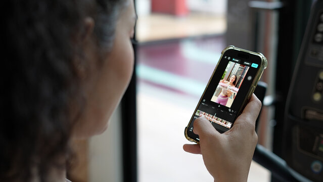 A woman uses a phone to edit a video.
