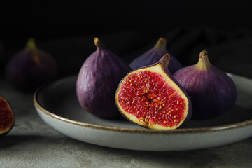 Plate with fresh ripe figs on grey table
