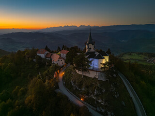 Evening view of the Church of the Birth of Mary atop Zasavska Sveta Gora, a historic pilgrimage site with Gothic and Baroque architecture.