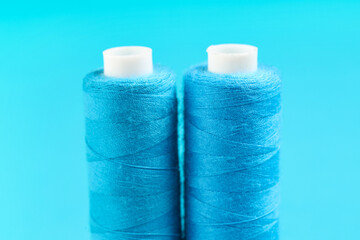 Spools of thread on blue background, closeup