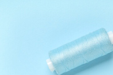 Spool of thread on blue background