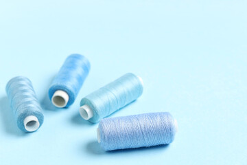 Spools of thread on blue background, closeup