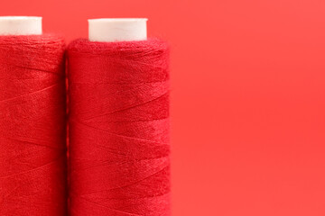 Spools of thread on red background, closeup