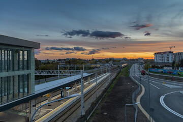 Modern Train Station and Railway Tracks at Sunset – Urban Landscape with City Skyline