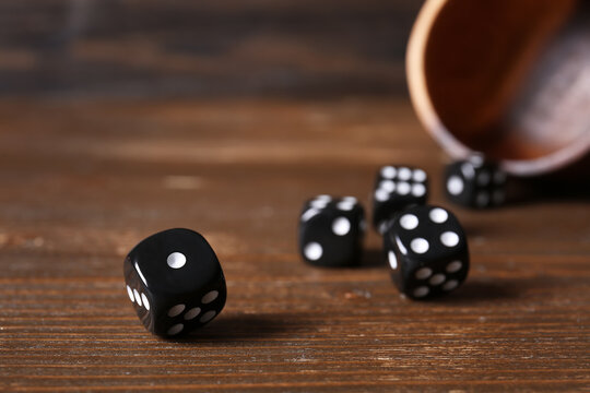 Black game dices on wooden background