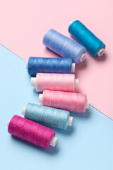 Set of different thread spools on color background, closeup