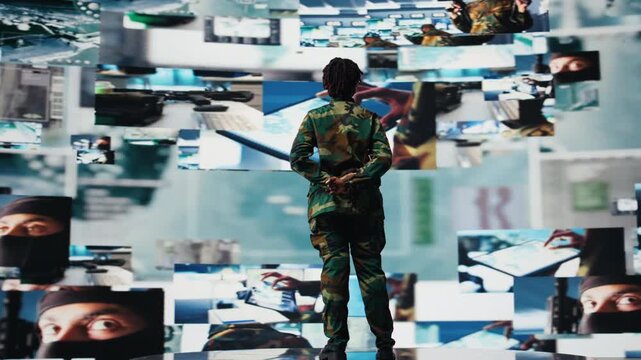 Soldier in command post providing combat support, watching reconnaissance feeds. African american intelligence agency expert looking at battlefield communication network videowall, camera A