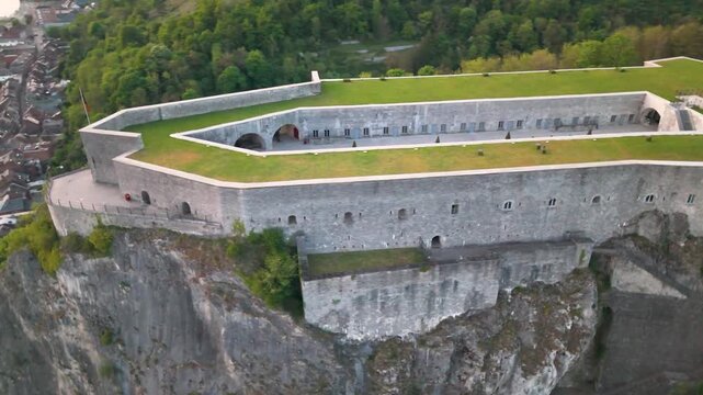 citadel atop mountain green cover town below meuse river flowing through dinant belgium scenic historic to from left right circling aerial shot top 
