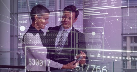 Colleagues wearing business attire reviewing data with stylus on tablet and overlay in office