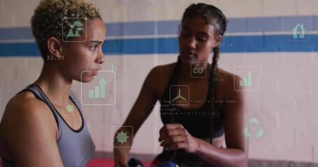 Preparing athletes in sports bras applying hand wraps in boxing gym, with gloves and hologram icons