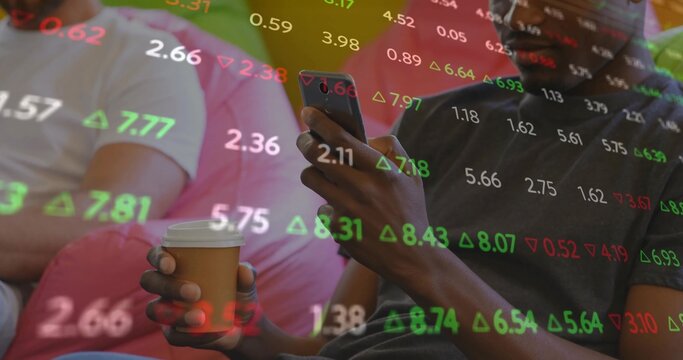 Holding paper coffee cup and smartphone, two friends watching stock market figures in living room
