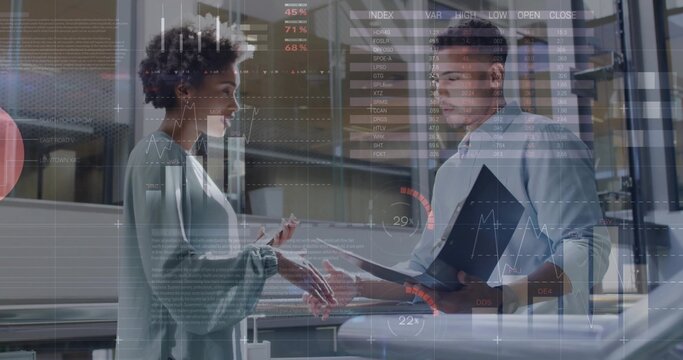 Two business analysts discussing data overlays in open-plan office, holding tablet and smartphone