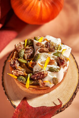 Pumpkin tart with cinnamon and nuts on rustic table, autumn dessert close up