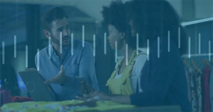 Gesturing consultant and women in yellow overalls discussing samples in studio, with measuring tape - Powered by Adobe