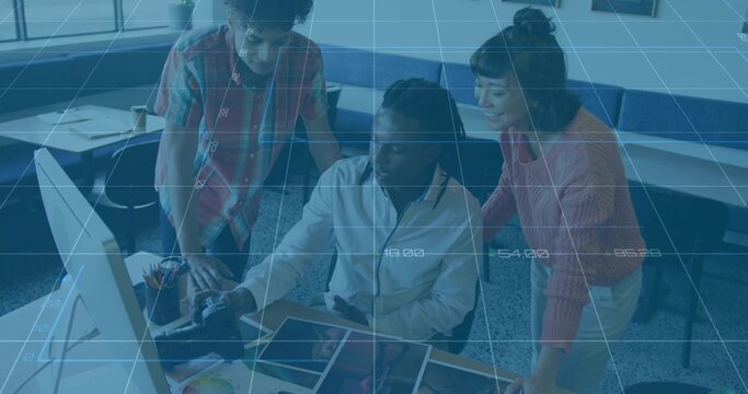 Collaborating design team reviewing photos and sketches at desk in office lounge with smartphone