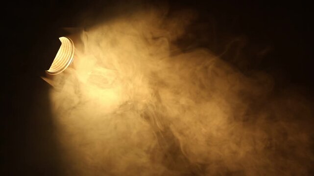 Professional lighting equipment without reflector and smoke flowing on dark background